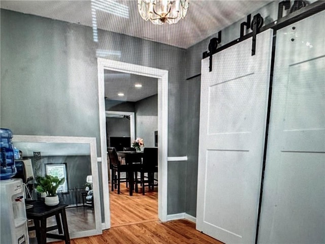 6404 N Harrison St, Oakview, MO 64118 - hall featuring wood finished floors, a chandelier, and a barn door
