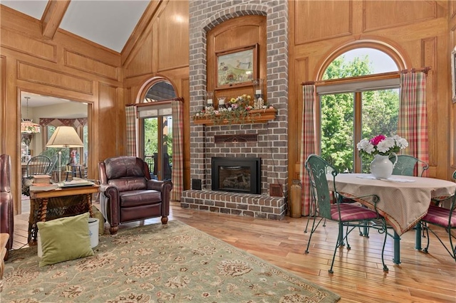 3644 W 127th Ter, Leawood, KS 66209 - living area featuring wood finished floors, high vaulted ceiling, a brick fireplace, wood walls, and beamed ceiling