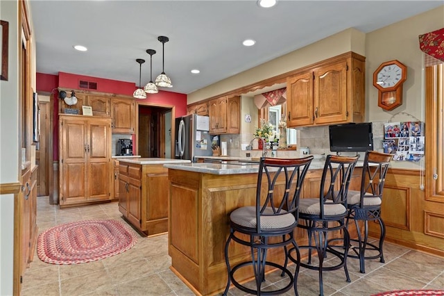 3644 W 127th Ter, Leawood, KS 66209 - kitchen with freestanding refrigerator, a kitchen island, brown cabinetry, light countertops, and recessed lighting