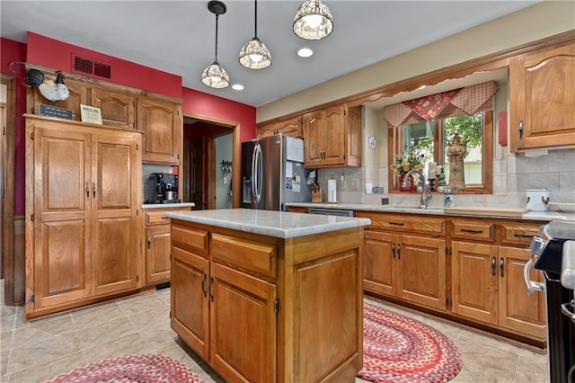 3644 W 127th Ter, Leawood, KS 66209 - kitchen with stainless steel appliances, a sink, light countertops, decorative backsplash, and brown cabinetry