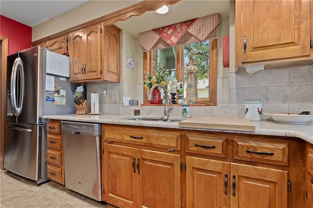3644 W 127th Ter, Leawood, KS 66209 - kitchen with appliances with stainless steel finishes, a sink, brown cabinetry, light countertops, and tasteful backsplash