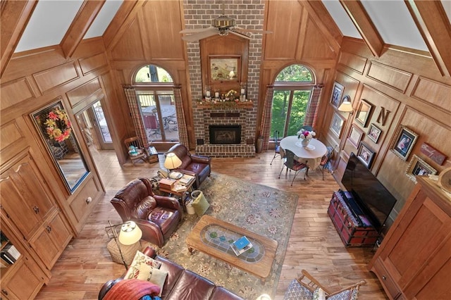 3644 W 127th Ter, Leawood, KS 66209 - living area featuring a brick fireplace, light wood-style floors, a decorative wall, lofted ceiling, and ceiling fan