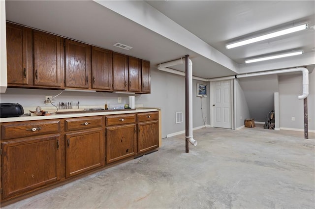 3644 W 127th Ter, Leawood, KS 66209 - kitchen featuring concrete floors, light countertops, brown cabinetry, and baseboards