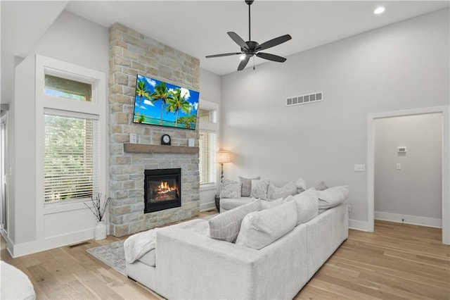 807 NE Algonquin St Unit B, Lees Summit, MO 64064 - living area with a stone fireplace, wood finished floors, ceiling fan, a high ceiling, and baseboards