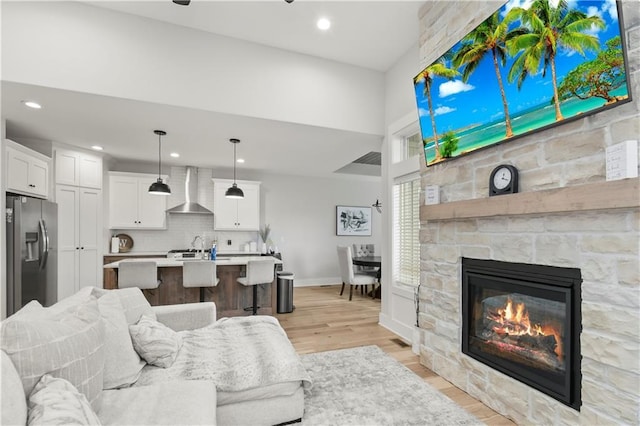 807 NE Algonquin St Unit B, Lees Summit, MO 64064 - living room with light wood-type flooring, a stone fireplace, recessed lighting, and baseboards