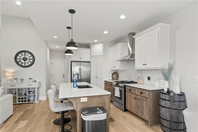 807 NE Algonquin St Unit B, Lees Summit, MO 64064 - kitchen with wall chimney range hood, stainless steel appliances, a sink, tasteful backsplash, and light wood-type flooring