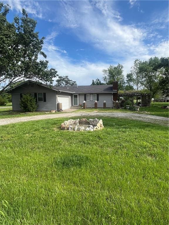 622 W Franklin St, Moran, KS 66755 - ranch-style home with driveway, a garage, a front lawn, and a carport