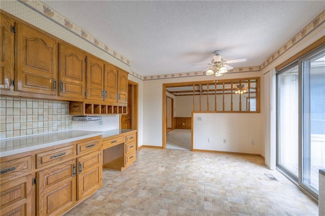 25908 Colbern Rd, Lees Summit, MO 64086 - kitchen featuring wallpapered walls, ceiling fan, light countertops, brown cabinets, and a textured ceiling