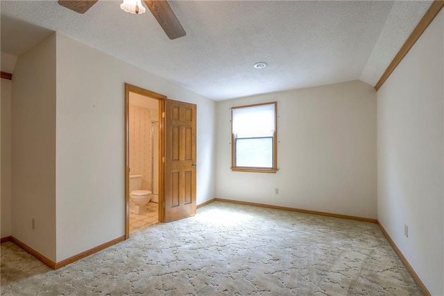 25908 Colbern Rd, Lees Summit, MO 64086 - unfurnished bedroom with light colored carpet, baseboards, vaulted ceiling, and a textured ceiling