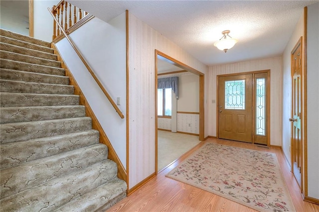 25908 Colbern Rd, Lees Summit, MO 64086 - entryway with stairs, light wood finished floors, baseboards, and a textured ceiling