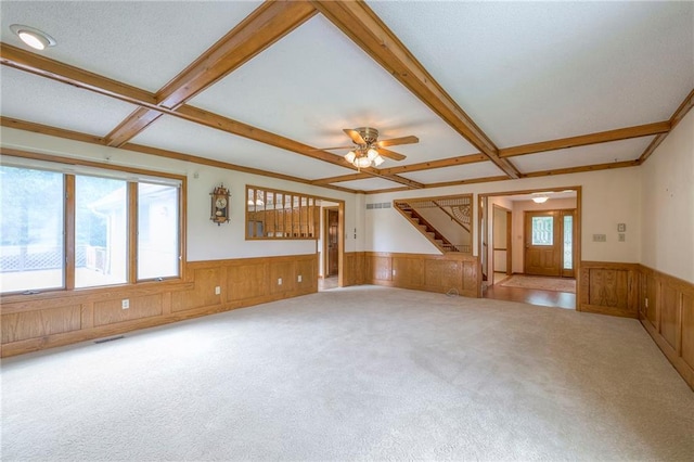 25908 Colbern Rd, Lees Summit, MO 64086 - unfurnished living room with a wainscoted wall, carpet floors, stairs, beam ceiling, and ceiling fan