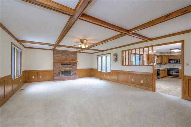 25908 Colbern Rd, Lees Summit, MO 64086 - unfurnished living room featuring a brick fireplace, a wainscoted wall, a ceiling fan, coffered ceiling, and beamed ceiling