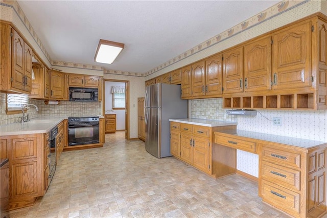 25908 Colbern Rd, Lees Summit, MO 64086 - kitchen featuring black appliances, wallpapered walls, brown cabinets, light countertops, and decorative backsplash