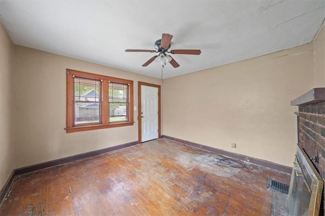 1111 S Cottage St, Independence, MO 64050 - unfurnished living room with baseboards, hardwood / wood-style floors, ceiling fan, and a fireplace