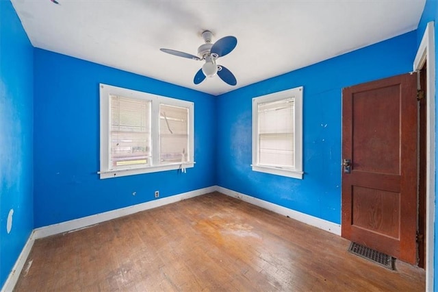 1111 S Cottage St, Independence, MO 64050 - empty room with healthy amount of natural light, ceiling fan, wood-type flooring, and baseboards