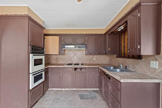 1111 S Cottage St, Independence, MO 64050 - kitchen featuring a sink, under cabinet range hood, white double oven, gas cooktop, and light countertops