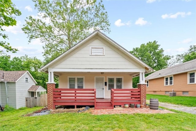 1111 S Cottage St, Independence, MO 64050 - view of front of home featuring a front lawn, cooling unit, and covered porch
