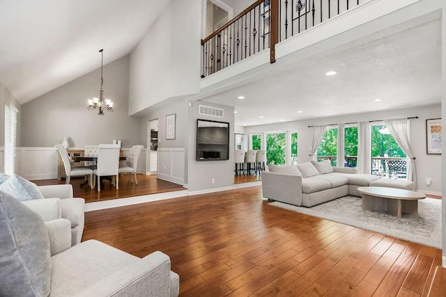 8911 W 104th St, Overland Park, KS 66212 - living room with wood finished floors, a chandelier, high vaulted ceiling, recessed lighting, and baseboards