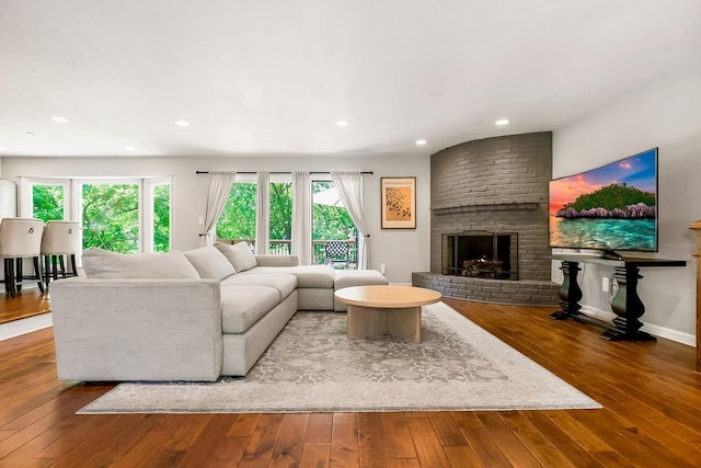 8911 W 104th St, Overland Park, KS 66212 - living room with wood-type flooring, a brick fireplace, recessed lighting, and baseboards
