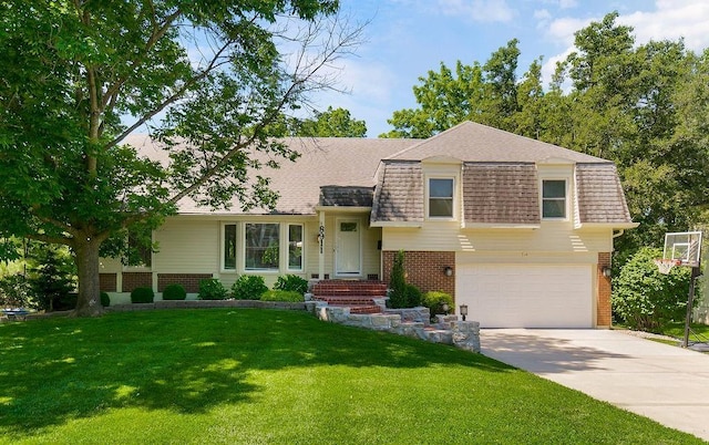 8911 W 104th St, Overland Park, KS 66212 - tri-level home featuring brick siding, roof with shingles, concrete driveway, and an attached garage