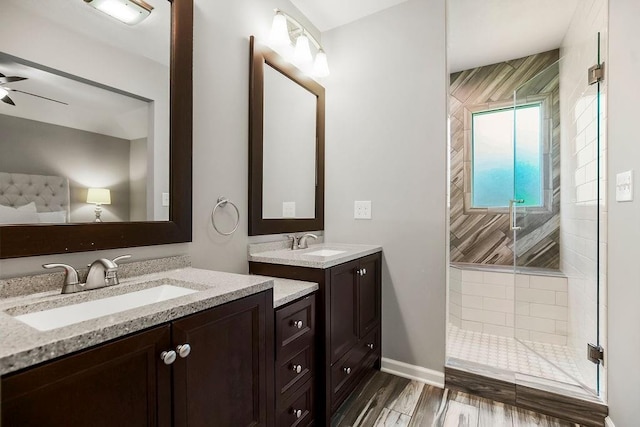 8911 W 104th St, Overland Park, KS 66212 - bathroom with a shower stall, two vanities, a ceiling fan, wood finished floors, and baseboards