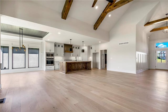 17556 Acton St, Overland Park, KS 66085 - unfurnished living room with beamed ceiling, light wood-type flooring, high vaulted ceiling, a sink, and recessed lighting