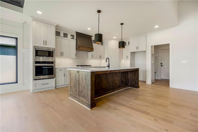 17556 Acton St, Overland Park, KS 66085 - kitchen featuring stainless steel appliances, light wood-style flooring, custom exhaust hood, recessed lighting, and light countertops
