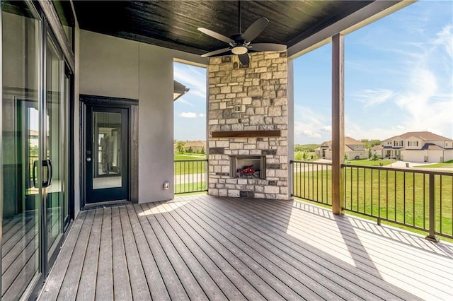 17556 Acton St, Overland Park, KS 66085 - deck featuring an outdoor stone fireplace, a ceiling fan, a residential view, and a yard