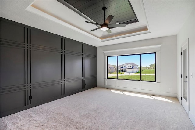 17556 Acton St, Overland Park, KS 66085 - unfurnished bedroom with a tray ceiling, carpet flooring, a decorative wall, and a ceiling fan