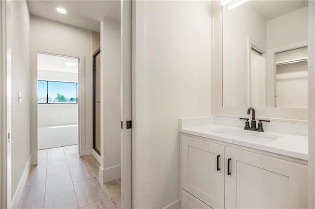 17556 Acton St, Overland Park, KS 66085 - bathroom featuring a shower stall, vanity, baseboards, and recessed lighting