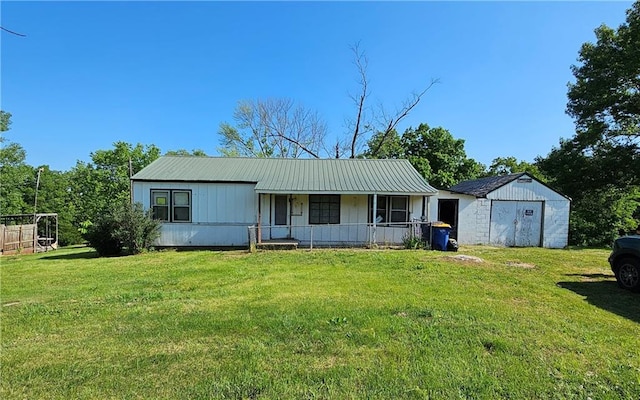 W 83rd St Unit 30720, De Soto, KS 66018 - view of front facade with covered porch, a storage unit, a front yard, an outbuilding, and metal roof