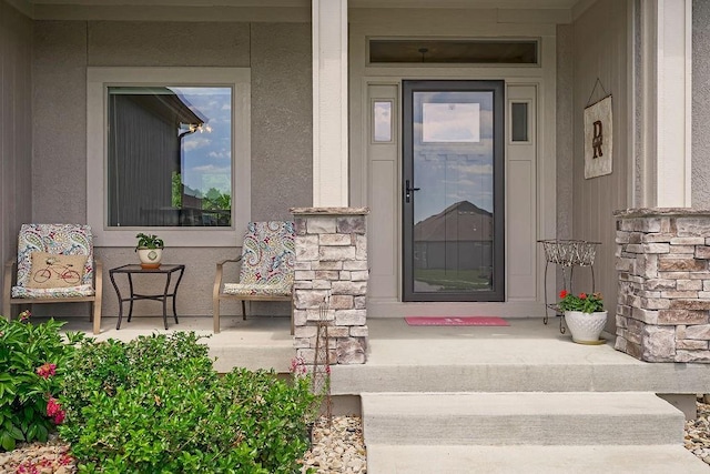 9305 SW Sushi Cir, Lees Summit, MO 64064 - entrance to property featuring covered porch, stone siding, and stucco siding