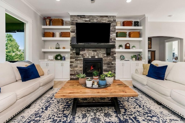 9305 SW Sushi Cir, Lees Summit, MO 64064 - living area with crown molding, arched walkways, a fireplace, light wood-style flooring, and built in features