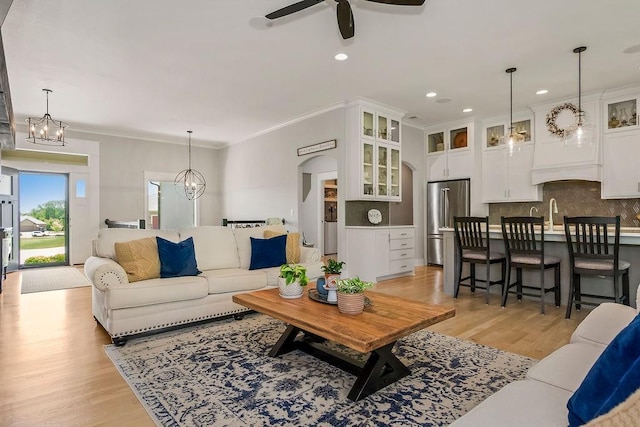 9305 SW Sushi Cir, Lees Summit, MO 64064 - living area featuring light wood-style floors, ceiling fan, recessed lighting, ornamental molding, and a chandelier