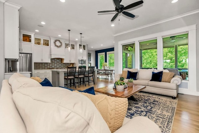 9305 SW Sushi Cir, Lees Summit, MO 64064 - living room featuring ceiling fan, recessed lighting, light wood-style flooring, and crown molding