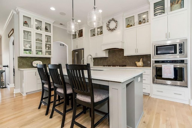 9305 SW Sushi Cir, Lees Summit, MO 64064 - kitchen featuring appliances with stainless steel finishes, a sink, light countertops, light wood-type flooring, and crown molding