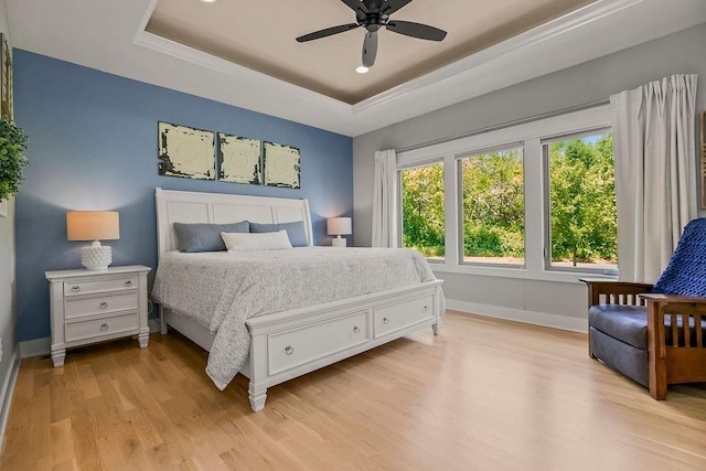 9305 SW Sushi Cir, Lees Summit, MO 64064 - bedroom with a tray ceiling, light wood-type flooring, baseboards, and ceiling fan