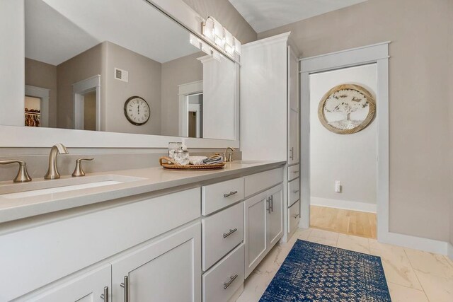 9305 SW Sushi Cir, Lees Summit, MO 64064 - full bathroom featuring double vanity, marble look tiles, and baseboards