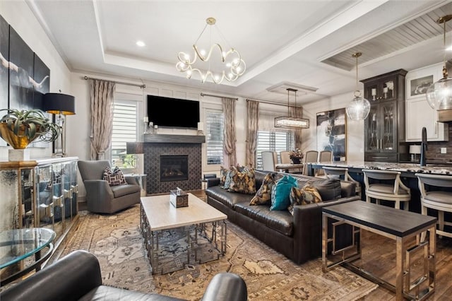 15278 W 173rd St, Olathe, KS 66062 - living area featuring wood finished floors, a glass covered fireplace, and a chandelier