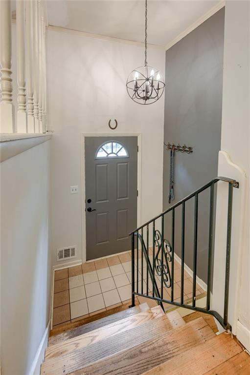 15609 E 43rd St S, Independence, MO 64055 - foyer entrance featuring a chandelier, baseboards, crown molding, and wood finished floors