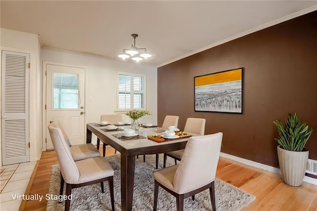 15609 E 43rd St S, Independence, MO 64055 - dining space with light wood-style floors, a chandelier, crown molding, and baseboards