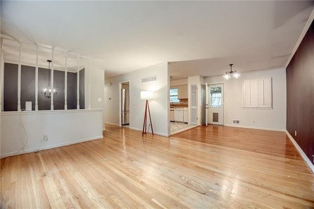 15609 E 43rd St S, Independence, MO 64055 - unfurnished living room featuring a chandelier, light wood-style flooring, baseboards, and ceiling fan
