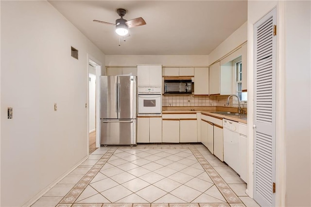 15609 E 43rd St S, Independence, MO 64055 - kitchen featuring white appliances, a sink, inlaid floor details, and light countertops