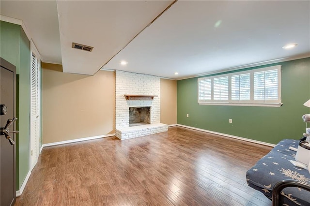 15609 E 43rd St S, Independence, MO 64055 - living area with ornamental molding, wood finished floors, baseboards, a brick fireplace, and recessed lighting