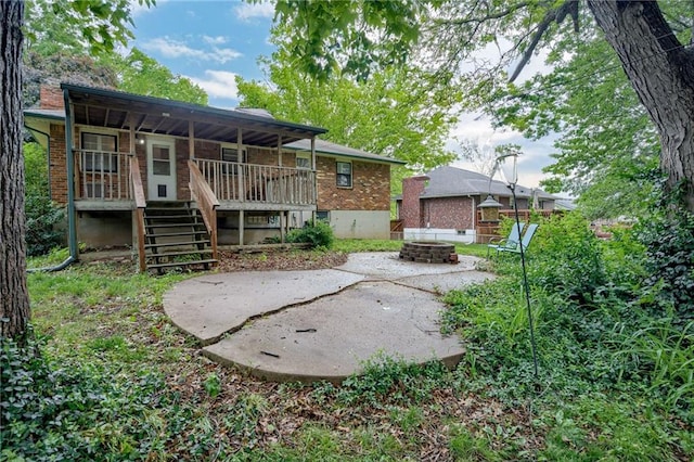 15609 E 43rd St S, Independence, MO 64055 - rear view of house featuring an outdoor fire pit, brick siding, stairway, and covered porch