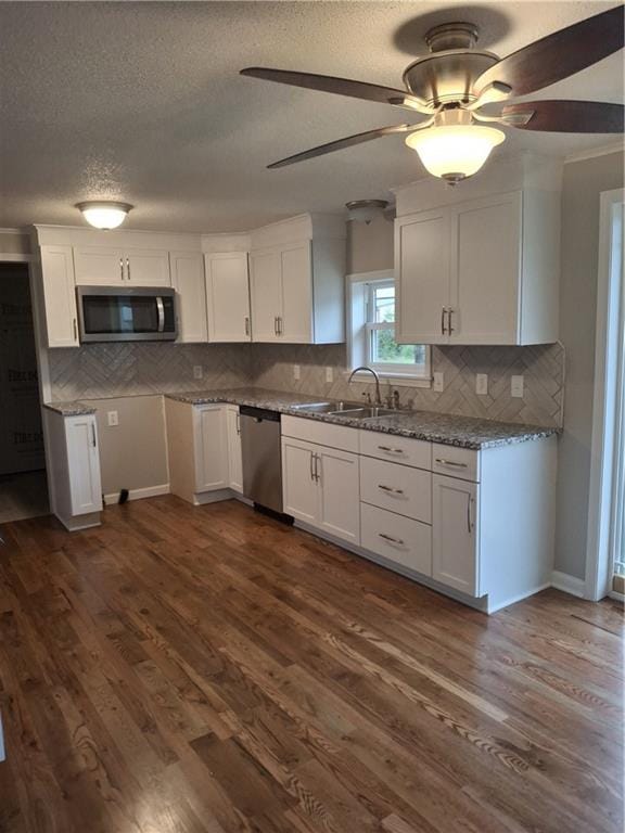 715 E Blackhawk St, Ottawa, KS 66067 - kitchen with stainless steel appliances, a sink, white cabinetry, decorative backsplash, and a textured ceiling