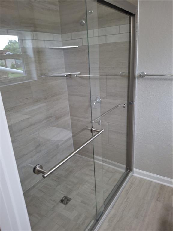 715 E Blackhawk St, Ottawa, KS 66067 - full bath featuring a stall shower, baseboards, and wood finished floors