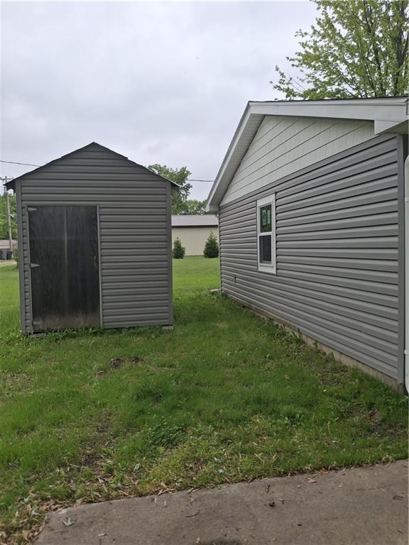 715 E Blackhawk St, Ottawa, KS 66067 - view of green lawn with an outdoor structure and a storage shed