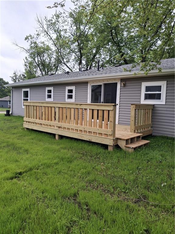 715 E Blackhawk St, Ottawa, KS 66067 - rear view of property featuring a deck, a lawn, and a shingled roof
