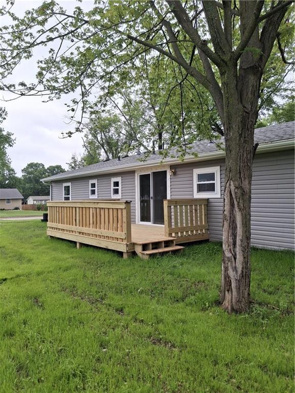 715 E Blackhawk St, Ottawa, KS 66067 - rear view of house with a wooden deck and a lawn